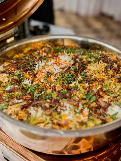 A close up of my traditional vegetable biryani in a copper serving dish. The colourful rice, fried onions, and fresh herbs make it a visually appealing and delicious main course.