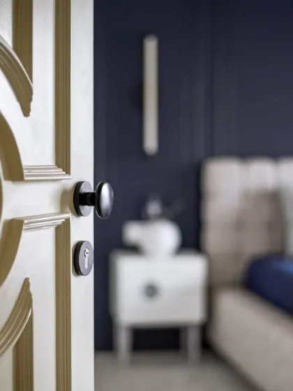 The view from the doorway into the guest bedroom. The custom-moulded door and the deep blue walls immediately set a tone of sophisticated tranquility.