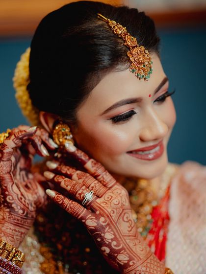 A close-up of the bride getting ready, with her beautifully stained hands adjusting her earring. It's these small moments that make a wedding so special.