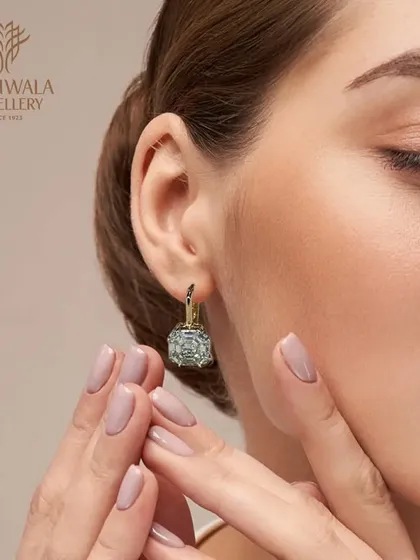 A model wears a pair of classic diamond huggie earrings, demonstrating their understated elegance and everyday appeal.
