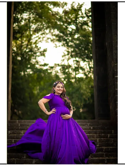 A confident pose on a stone staircase, with the purple gown creating a beautiful and dramatic look.