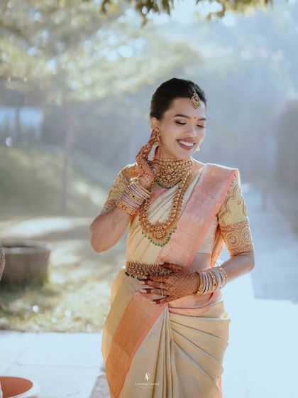 A candid shot of the bride, laughing happily in her beautiful Kanchipuram saree. Her genuine joy is infectious.