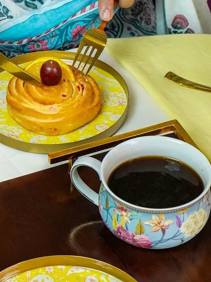 A close-up action shot of someone cutting into a pastry, showcasing the elegant tableware in use.