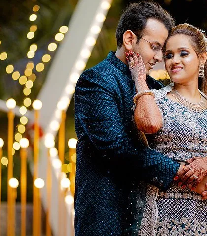 An intimate engagement portrait. The couple's close embrace and the warm bokeh background create a dreamy and romantic mood.