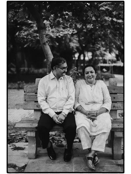 A sweet black and white portrait of a couple on a park bench. Their shared glance and smiles speak to a lifetime of love and companionship.