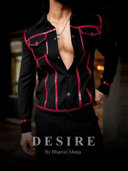 A detail shot of the black and red piped jacket, focusing on the bold lines and the texture of the fabric.