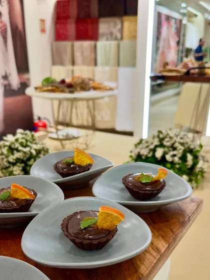 Rich chocolate tarts with a candied orange slice, a sophisticated dessert option served at the Tasva fashion launch.
