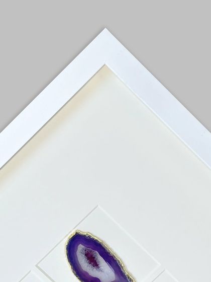 A corner detail with a purple 'Amethyst' agate stone. This view shows how the stone is mounted to appear as if it's floating, adding to the modern aesthetic.