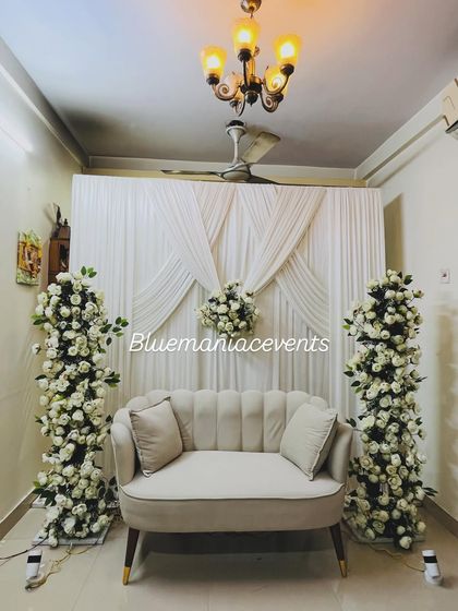 This full view of the Roka setup shows how it transforms a regular room into a special event space. The combination of the floral pillars, draped backdrop, and elegant sofa creates a complete and professional look.
