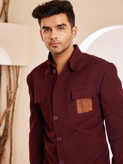 A frontal view of the maroon shacket, highlighting its clean design and the contrasting leather pocket detail that sets it apart.