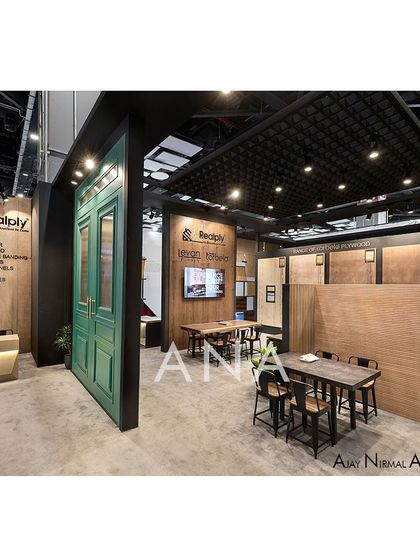 Inside the Realply '23 interactive zone, an industrial aesthetic was achieved with dark grey tones and exposed structures. A large green door adds a pop of color and classical detail to the otherwise modern space.