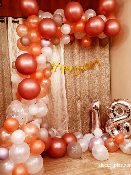 A simple and elegant 18th birthday decoration at home. This setup uses a beautiful color palette of rose gold, peach, and white balloons to create a sophisticated half-arch, perfect for a stylish celebration.