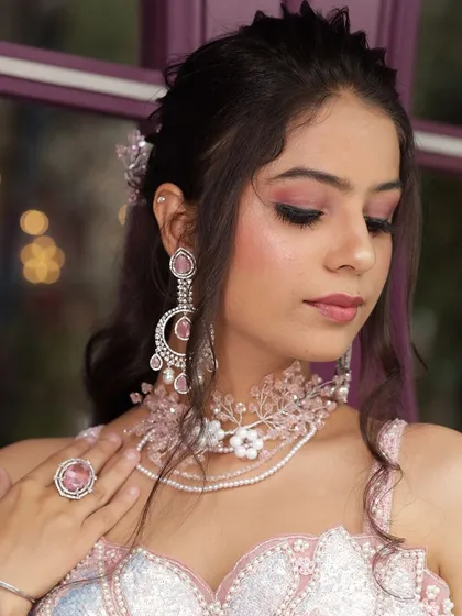 Two close-up shots of a model wearing our custom pink floral jewellery set. This is perfect for showcasing delicate, modern accessory styling.