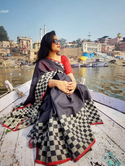 Style is a journey, not a destination. Here, on a boat in the serene ghats of Varanasi, a timeless checkered saree tells a story of heritage and grace. I help you find outfits that honor your roots while feeling completely modern.