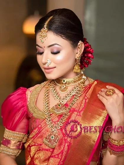 A serene pose that beautifully displays the layered necklaces and puff-sleeved blouse, a popular combination in South Indian weddings.