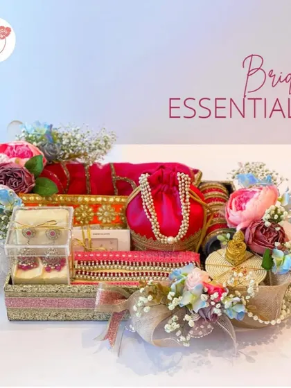 A full view of the "Bridal Essentials" hamper, a vibrant collection of traditional pouches, jewelry, and other accessories in bright pinks and oranges.