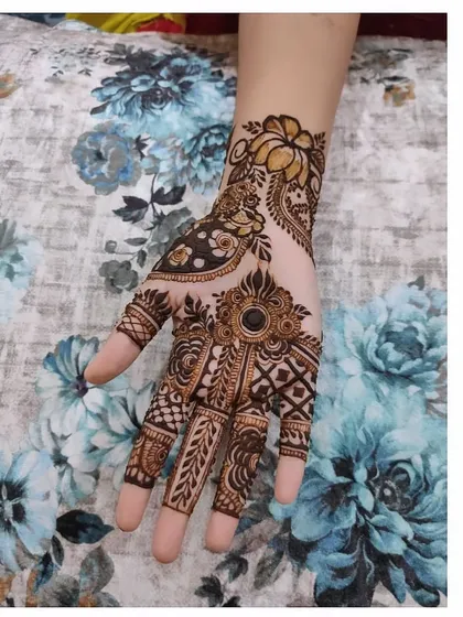 This is a modern take on a traditional design, with a central jewel-like motif and detailed patterns on each finger.