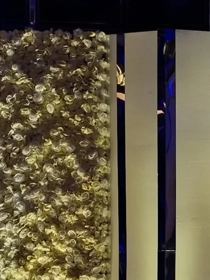 A detail shot of the custom decor, showing a dense wall of white flowers next to a sleek, modern panel. This juxtaposition of soft and hard textures is a signature of our contemporary designs.