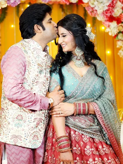 A tender moment captured forever. The groom's gentle kiss on his fiancée's forehead is a perfect picture of love and affection.