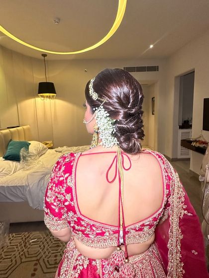 This side view shows how the textured updo is complemented with delicate baby's breath. The combination of the sleek, woven hair and the soft flowers creates a beautiful contrast.