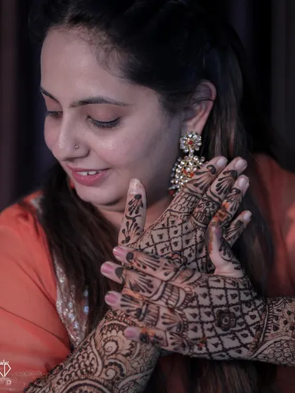 The bride admiring her intricate Mehandi design, a moment of quiet appreciation before the wedding.