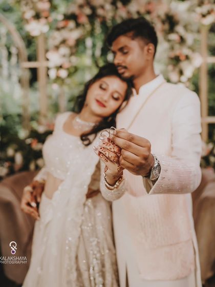A creative shot focusing on the engagement rings, held by the couple.