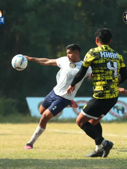 A player prepares to cross the ball, demonstrating technique under pressure from a defender.