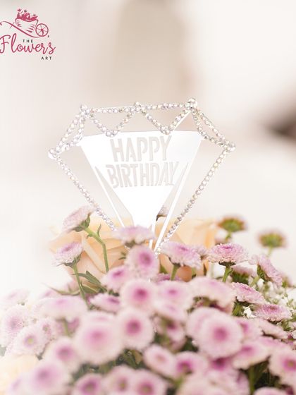 A close-up of the elegant 'Happy Birthday' topper, which adds a celebratory and personal touch to the floral gift. It's these small details that make a gift feel truly special.