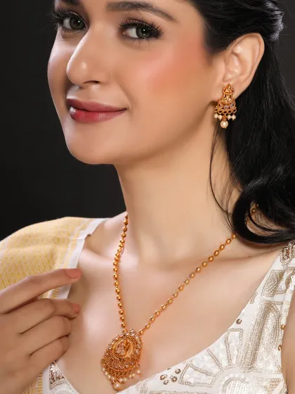 This close-up focuses on a model wearing a traditional gold necklace with pearl detailing. The angle highlights the texture and design, providing a clear view for customers on an e-commerce site.