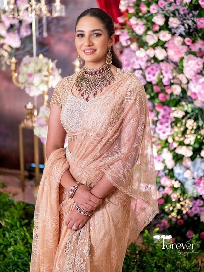 A smiling portrait against the floral decor of the engagement party.