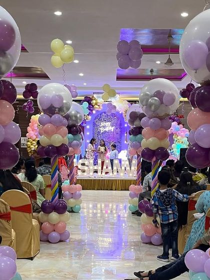 I created a grand entrance walkway with custom balloon pillars topped with bubble balloons, leading guests to the main butterfly-themed party area.
