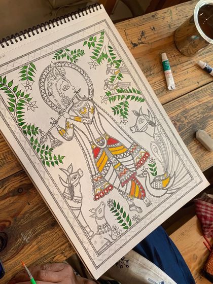 A Madhubani painting of Krishna in progress. We are reminded of his wisdom: 'You have the right to work, but never to the fruit of work.' This philosophy is at the heart of our creative process.