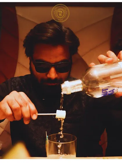 Creating a unique candy-infused drink. Here, I am pouring a spirit over a marshmallow, melting it into the glass for a sweet and surprising flavor.