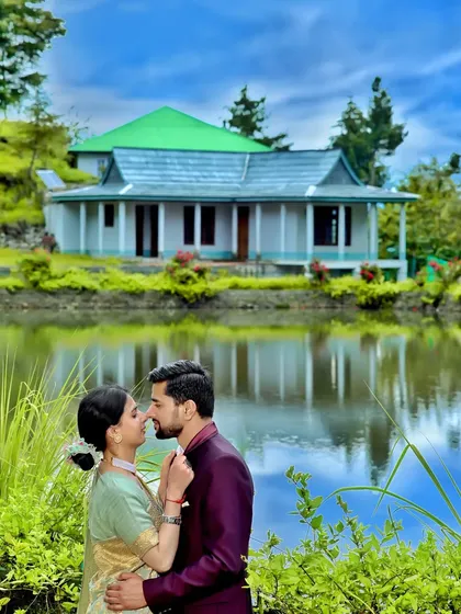 A quiet moment for a couple during their pre-wedding shoot, with a traditional Himachali house reflecting in the water. This is the kind of magic we can create in the mountains, finding serene spots that make your story unique.