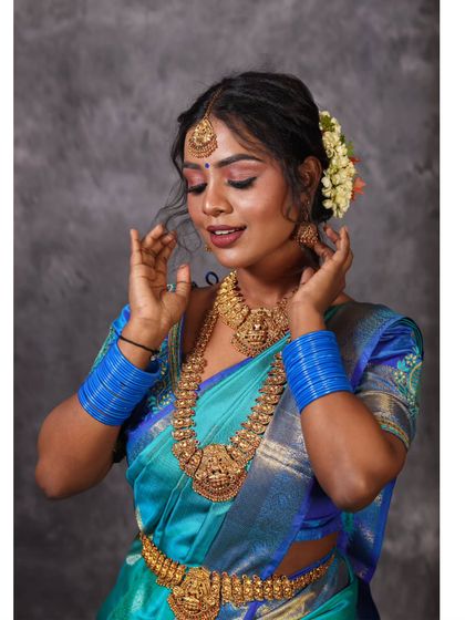 A serene pose in a blue saree, captured in the studio. The focus is on the graceful details and the subject's calm expression.