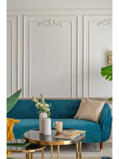 A close-up on the elegant details: the fluted sofa, the marble-topped coffee table, and the delicate flowers. We focus on these small touches to elevate the overall design.
