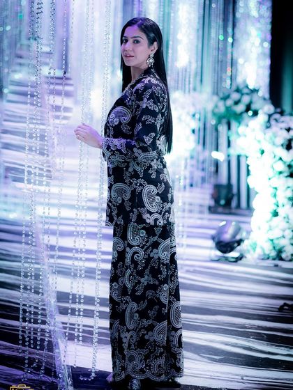 A side profile of the black and white set, showing the full paisley print and the flow of the outfit.