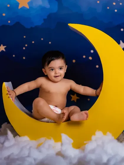 Twinkle, twinkle, little star. A simple and adorable shot of a baby sitting on the crescent moon.
