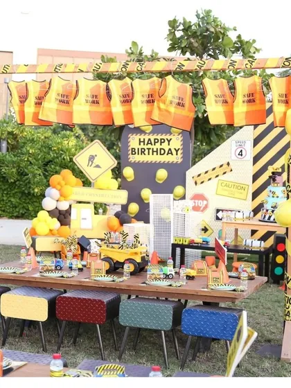 A construction-themed party with a fully decorated kids' table. The setup includes safety vests for the little workers, caution tape, and themed tableware.