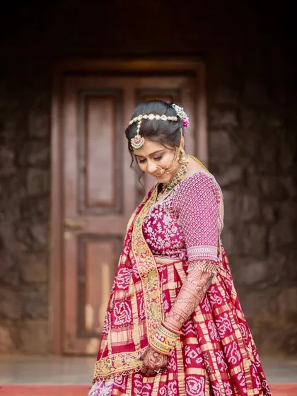 This bride's look is a beautiful example of soft glam. The makeup features blush tones on the eyes and cheeks, paired with a traditional bandhani-style dupatta, creating a look that is both modern and rooted in tradition.