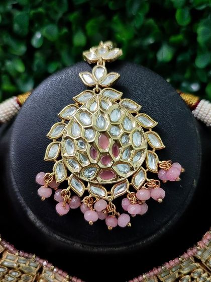 A close-up of the maang tikka from the pink set, showing its intricate design.