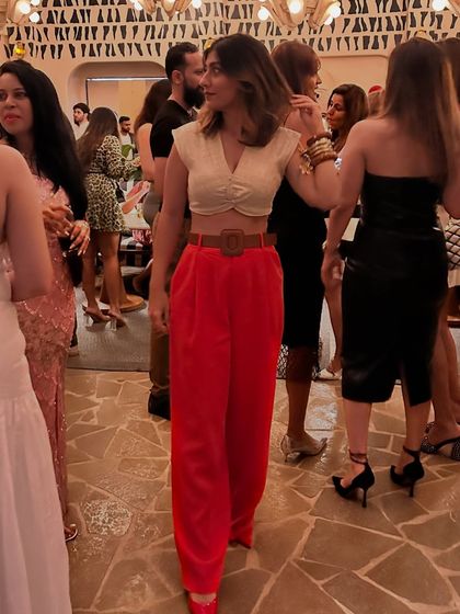 A party look with the red trousers, paired with a cream crop top and a statement belt.