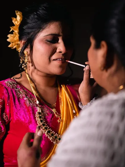 A candid moment during the makeup application, giving a glimpse into the process of creating the final look.