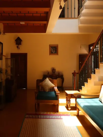 Sunlight falls across the living room floor, highlighting the simple elegance of the wooden furniture and the natural textures of the home.