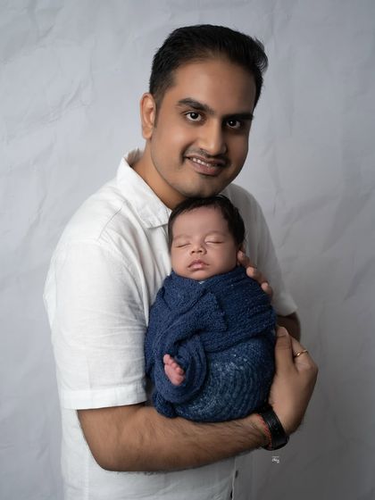 A proud father holding his newborn son. I love capturing these strong yet gentle moments that highlight the new bond between a father and his child.