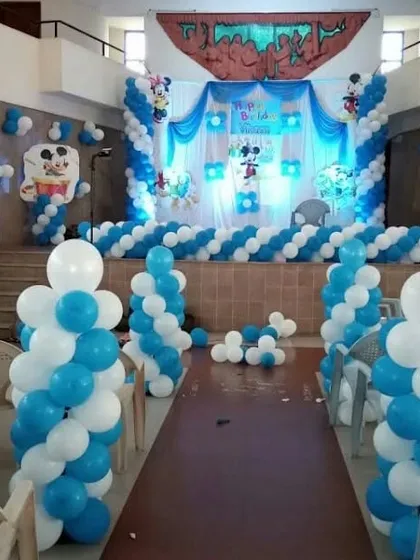 A large-scale hall decoration for a Mickey Mouse themed party, including an entrance path lined with balloon pillars.