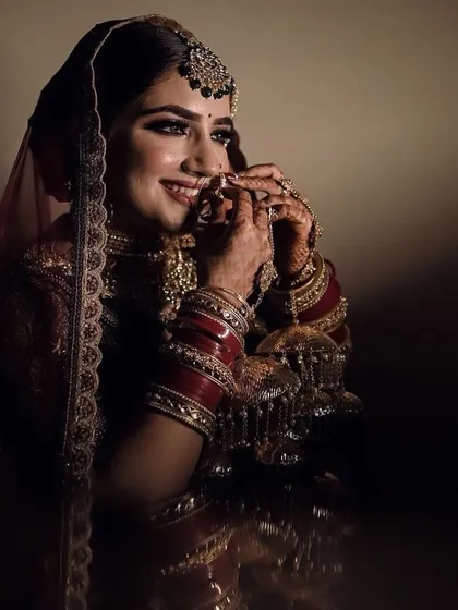A beautiful candid shot of the bride adjusting her nath. Her smile is so genuine and pretty.