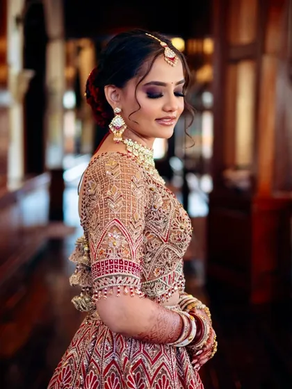 A side profile showcasing the elegant hairstyle and the flawless finish of her makeup. Every detail was considered to create a cohesive and stunning bridal look.