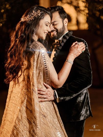 Radhika and Keshav share a happy, intimate dance. The warm lighting and her beautiful golden lehenga create a feeling of warmth and celebration.