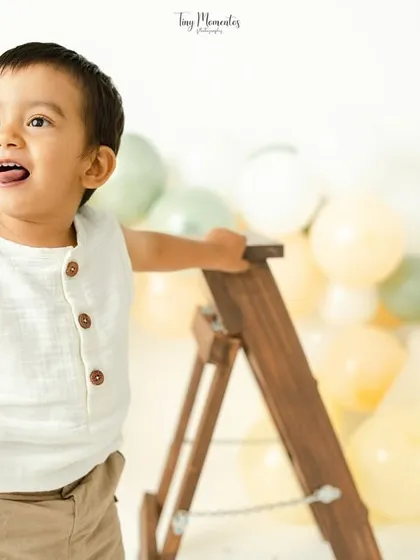 A joyful shout from this little explorer. The boho-themed milestone session with a ladder prop encourages natural play and big expressions.